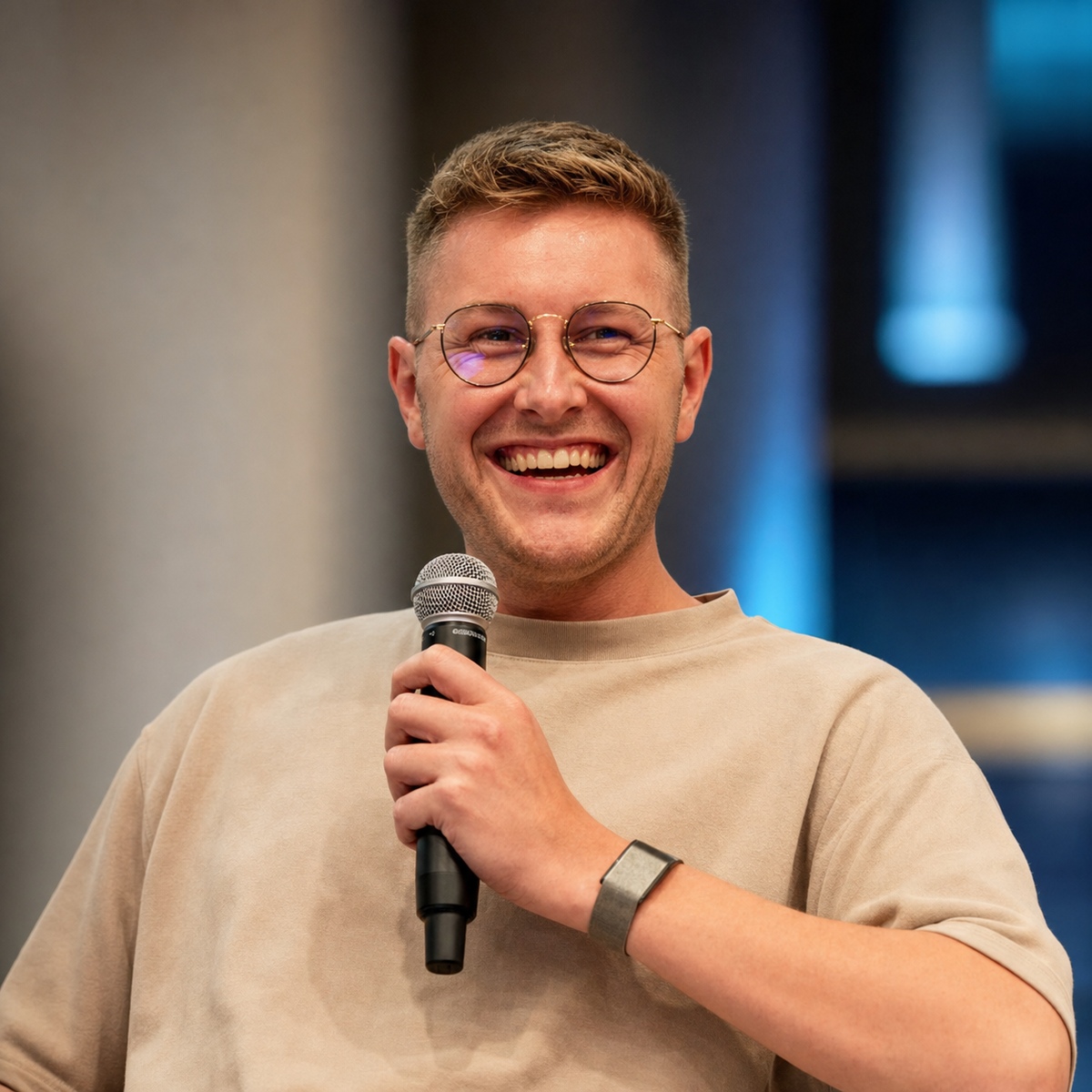 Jannik Reinhard spricht mit Mikrofon auf einer Bühne.